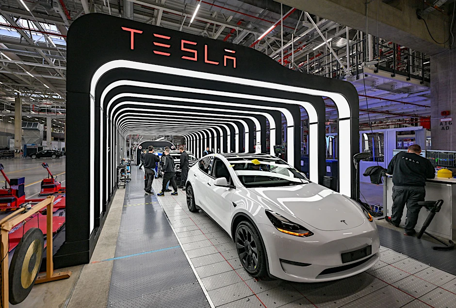 Mitarbeiter der Tesla Gigafactory Berlin Brandenburg arbeiten an der Endkontrolle der fertigen Elektrofahrzeuge vom Typ Model Y.