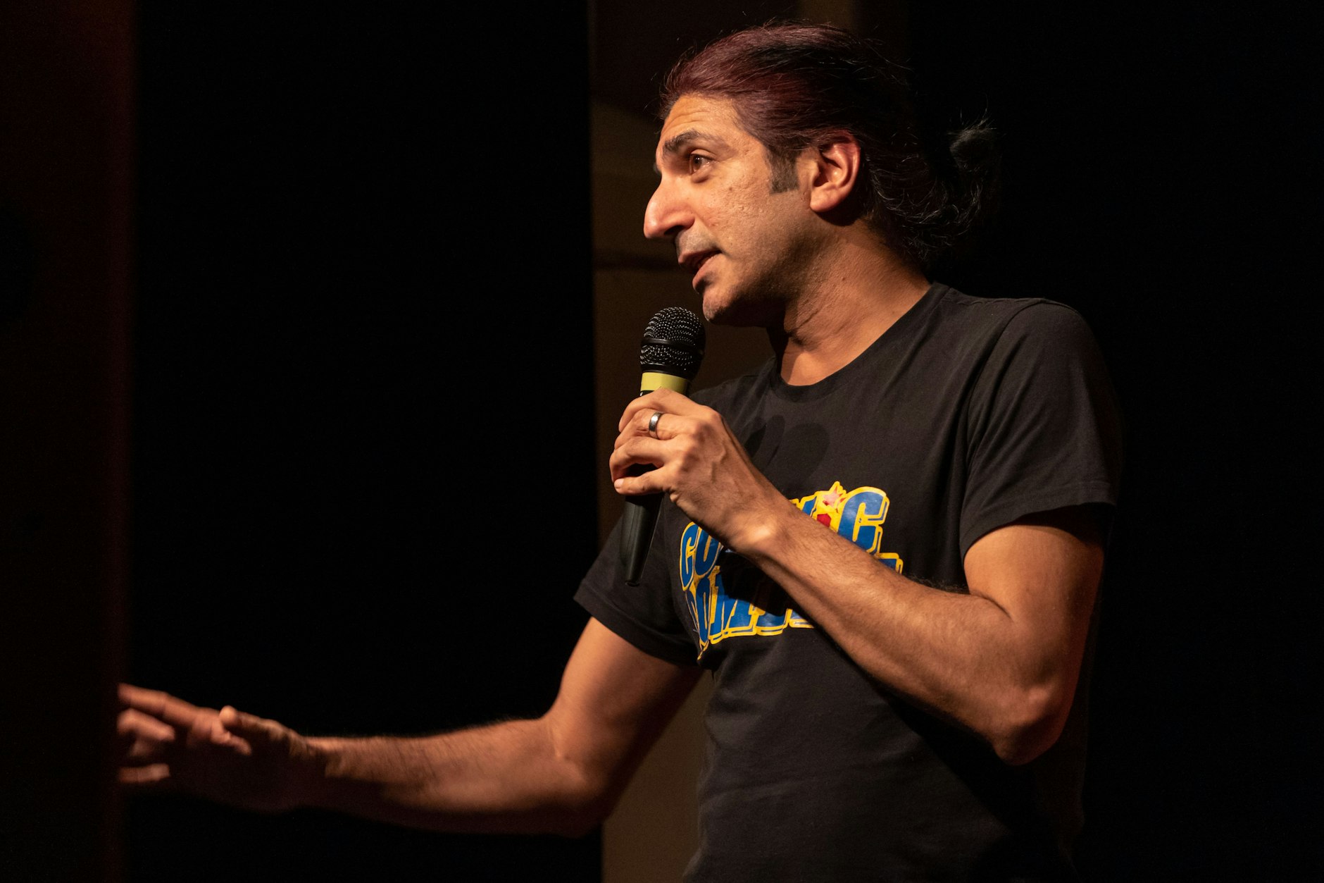 Der britische Comedian Dharmander Singh auf der Bühne.