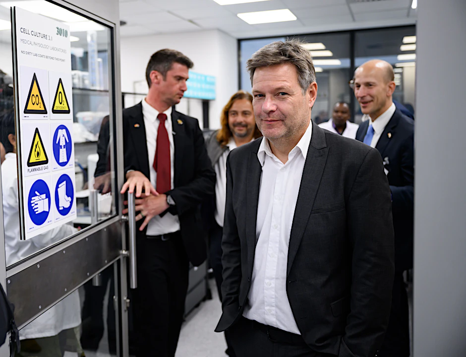 Robert Habeck lächelt, während er durch das Biomedical Research Institute (BMRI) in Kapstadt, Südafrika, geführt wird.