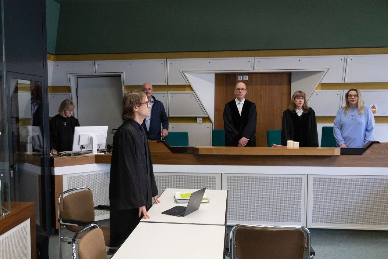 Bild-Motiv: der Verteidiger vor der leeren Anklagebank, der Angeklagte hat sich nicht vorführen lassen.