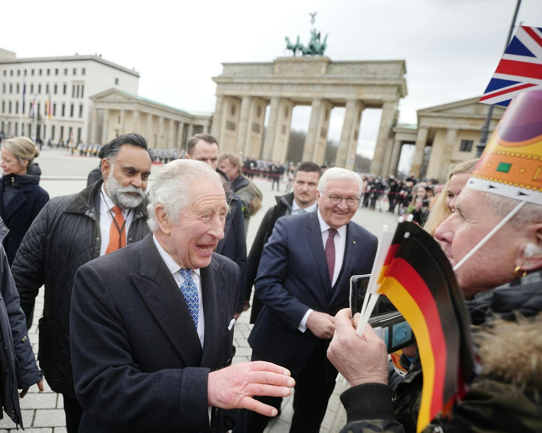 König Charles III. von Großbritannien schüttelt Hände. Zusammen mit Bundespräsident Frank-Walter Steinmeier genießt er den Smalltalk mit den Besuchern.