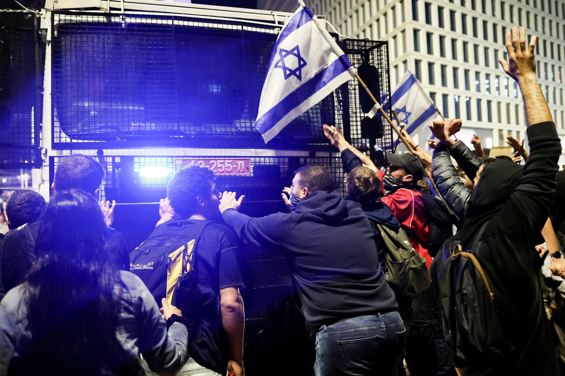Demonstranten in Tel Aviv blockieren ein Polizeifahrzeug, um einen Protest gegen die von Ministerpräsident Benjamin Netanjahu geplante Reform des Rechtssystems zu zerstreuen. Netanjahu hat einen vorläufigen Stopp der umstrittenen Justizreformen bestätigt.