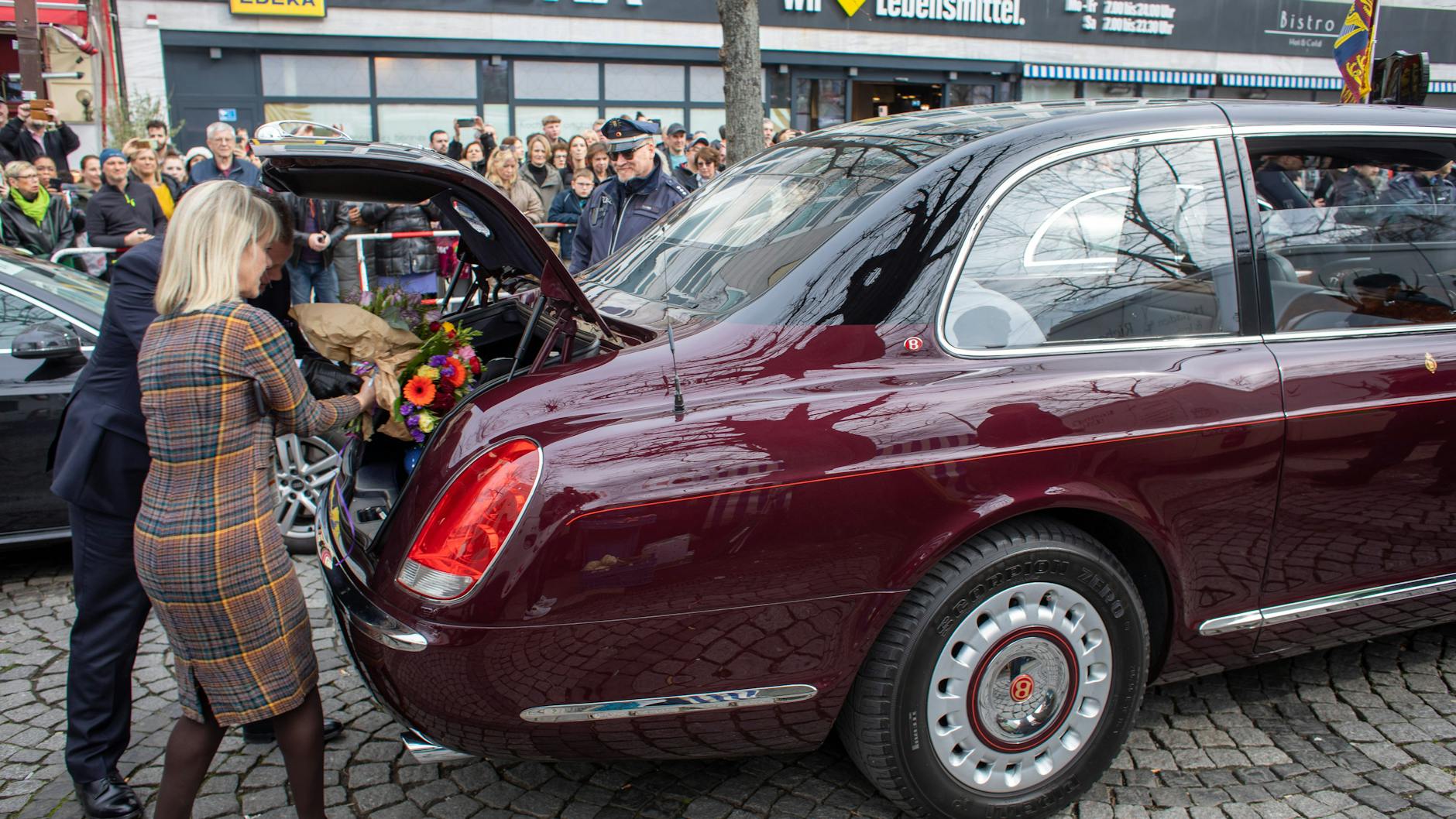 Die Blumen und Geschenke, darunter eine Vase für Camilla, werden in den Kofferraum des Bentley des Monarchen-Paares gepackt.