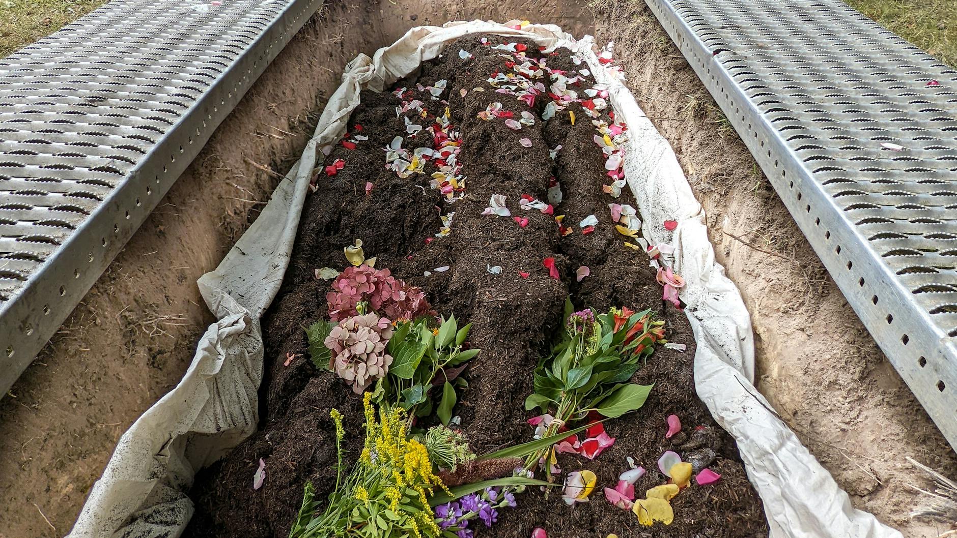Die Erde wird auf einem Friedhof beigesetzt.