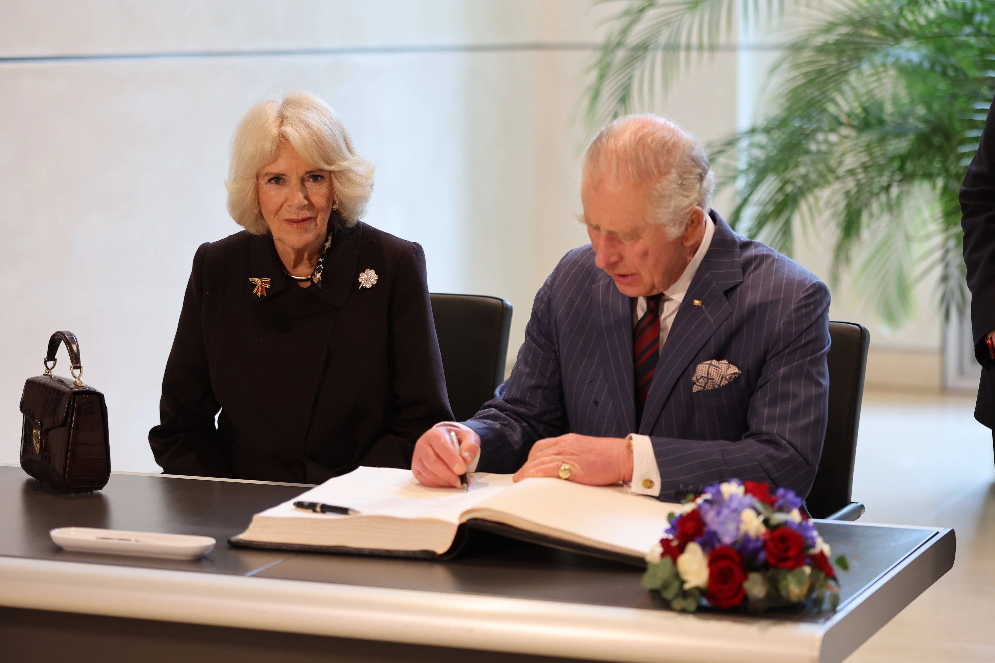 Sitzt alles tadellos: Camilla schwarz ummantelt und Charles im feinen Nadelstreifen im Reichstag.