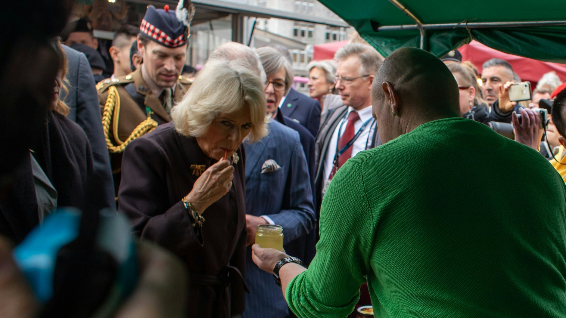 Camilla probiert auf dem Wochenmarkt köstlichen Honig.
