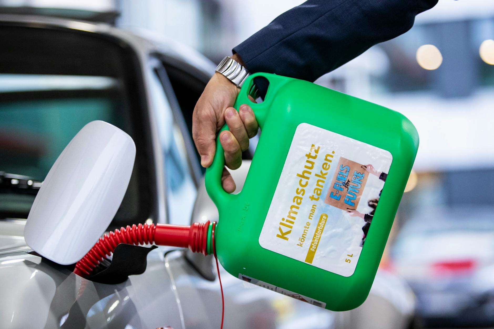 Ein Auto wird mit E-Fuel aus einem Kanister mit der Aufschrift „Klimaschutz könnte man tanken – E-Fuels for Future“ in Stuttgart getankt.