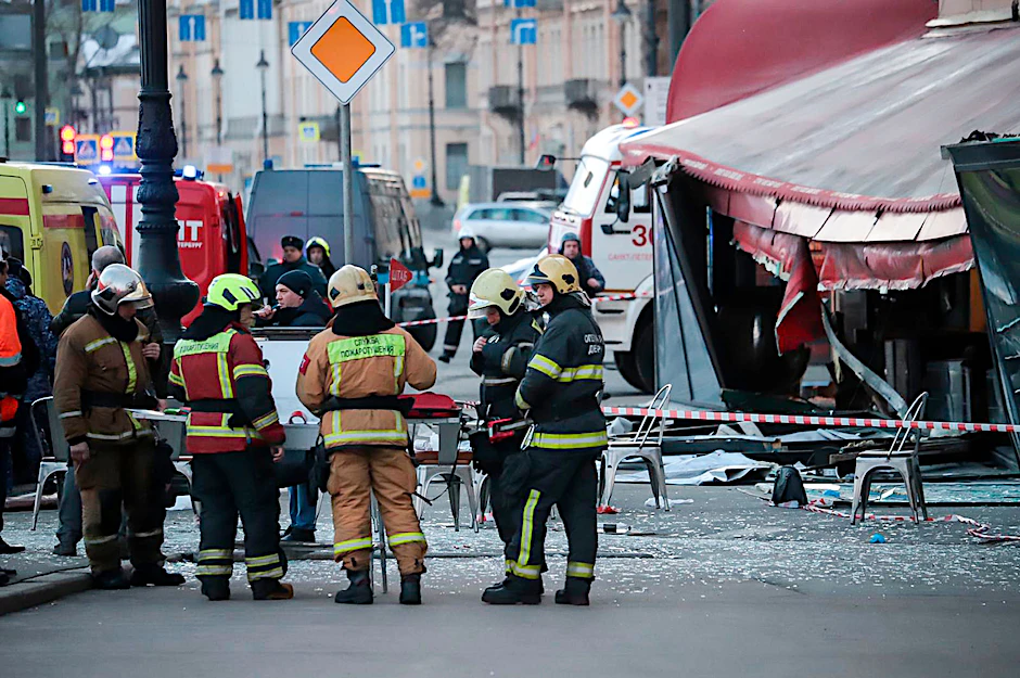 Rettungskräfte beraten sich neben dem Café, in dem am Sonntag ein Sprengsatz explodierte.