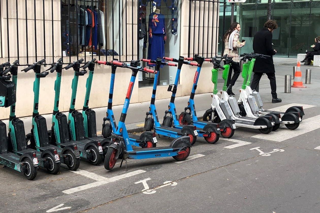 Paris: E-Scooter von drei verschiedenen Anbietern stehen auf einem dafür vorgesehenen Parkplatz.