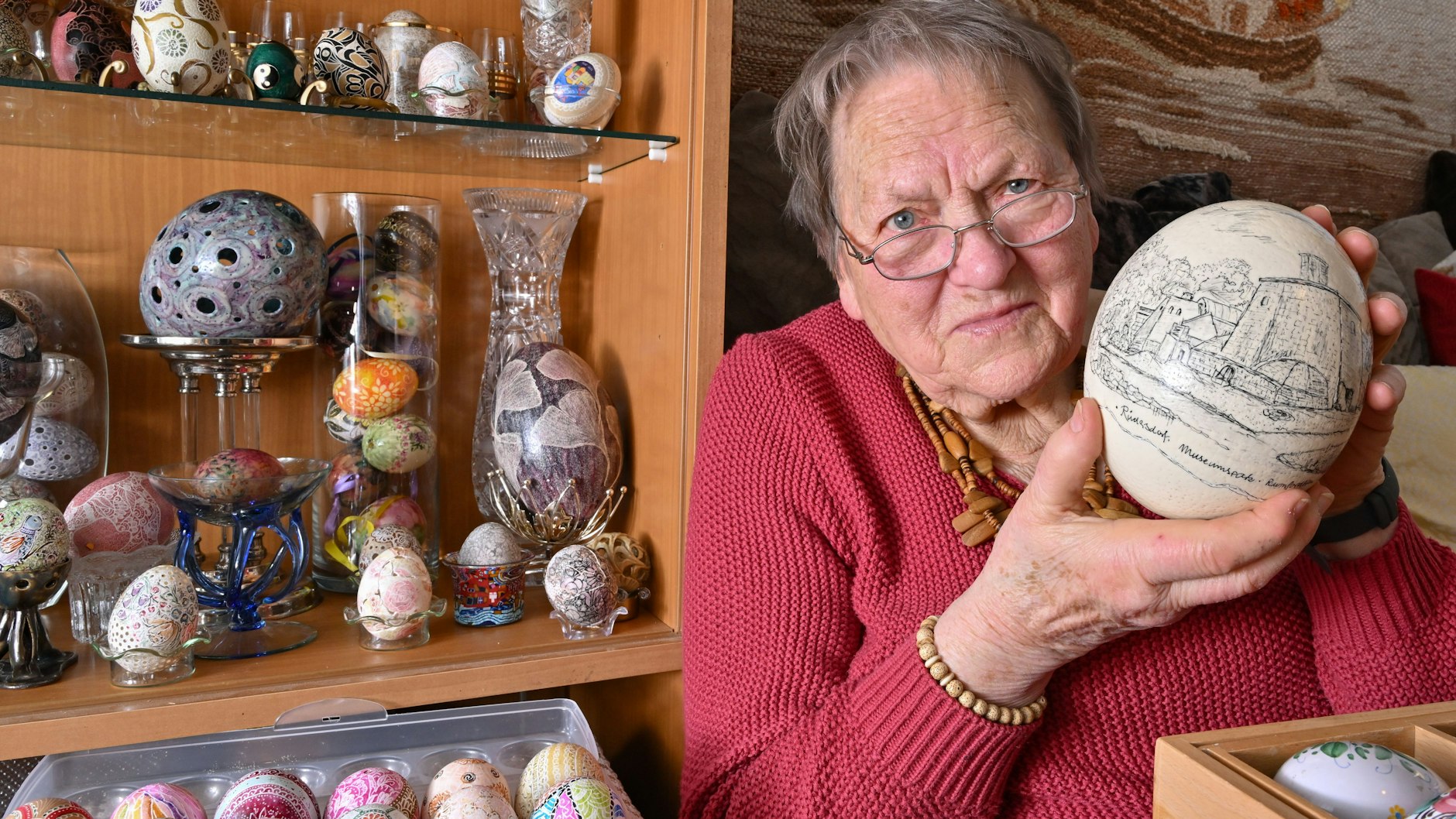 Renate Radoy zeigt ein Straußenei, das sie mit einem Motiv vom Museumspark Rüdersdorf gestaltet hat.