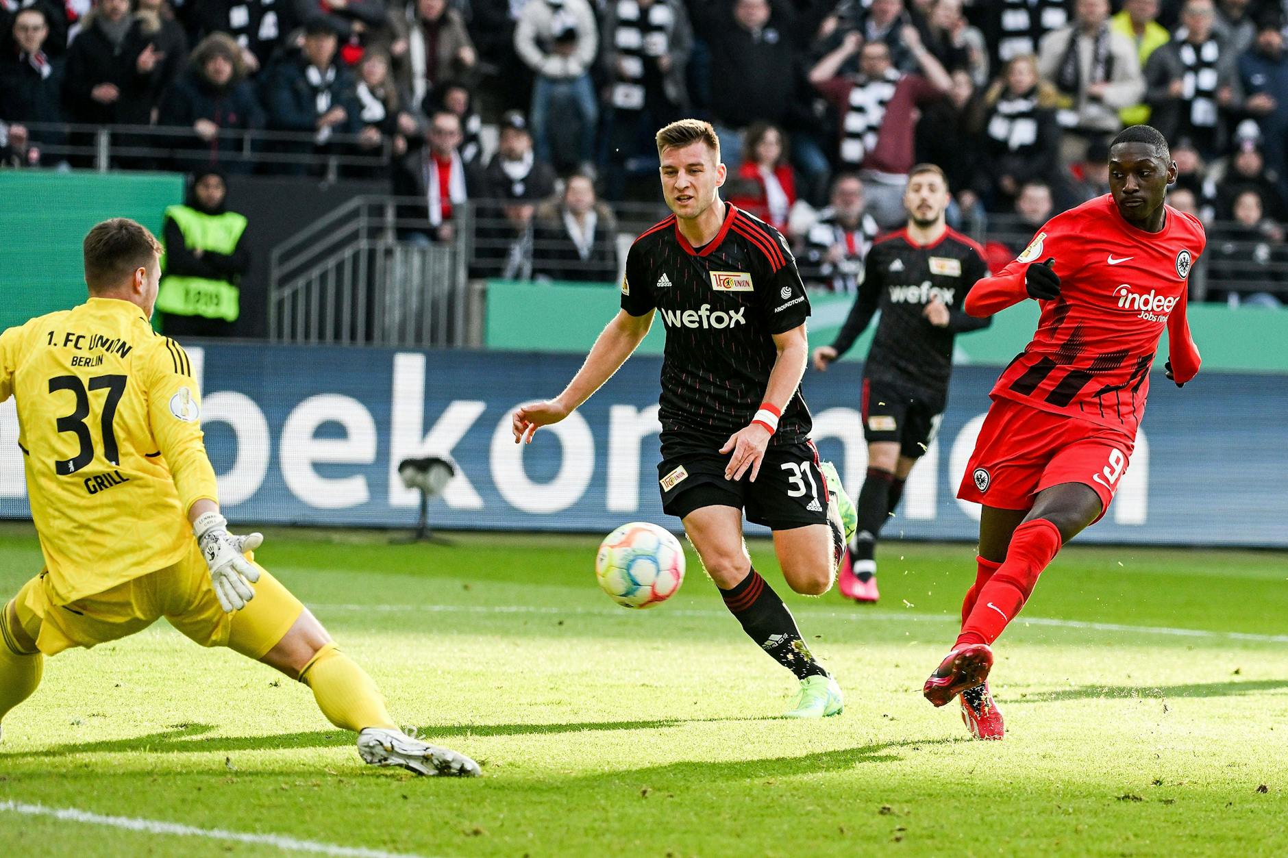 Eintracht Frankfurts Stürmer Randal Kolo Muani (r.) lässt Union Berlins Torwart Lennart Grill (l.) beim 1:0 für die Gastgeber keine Chance.
