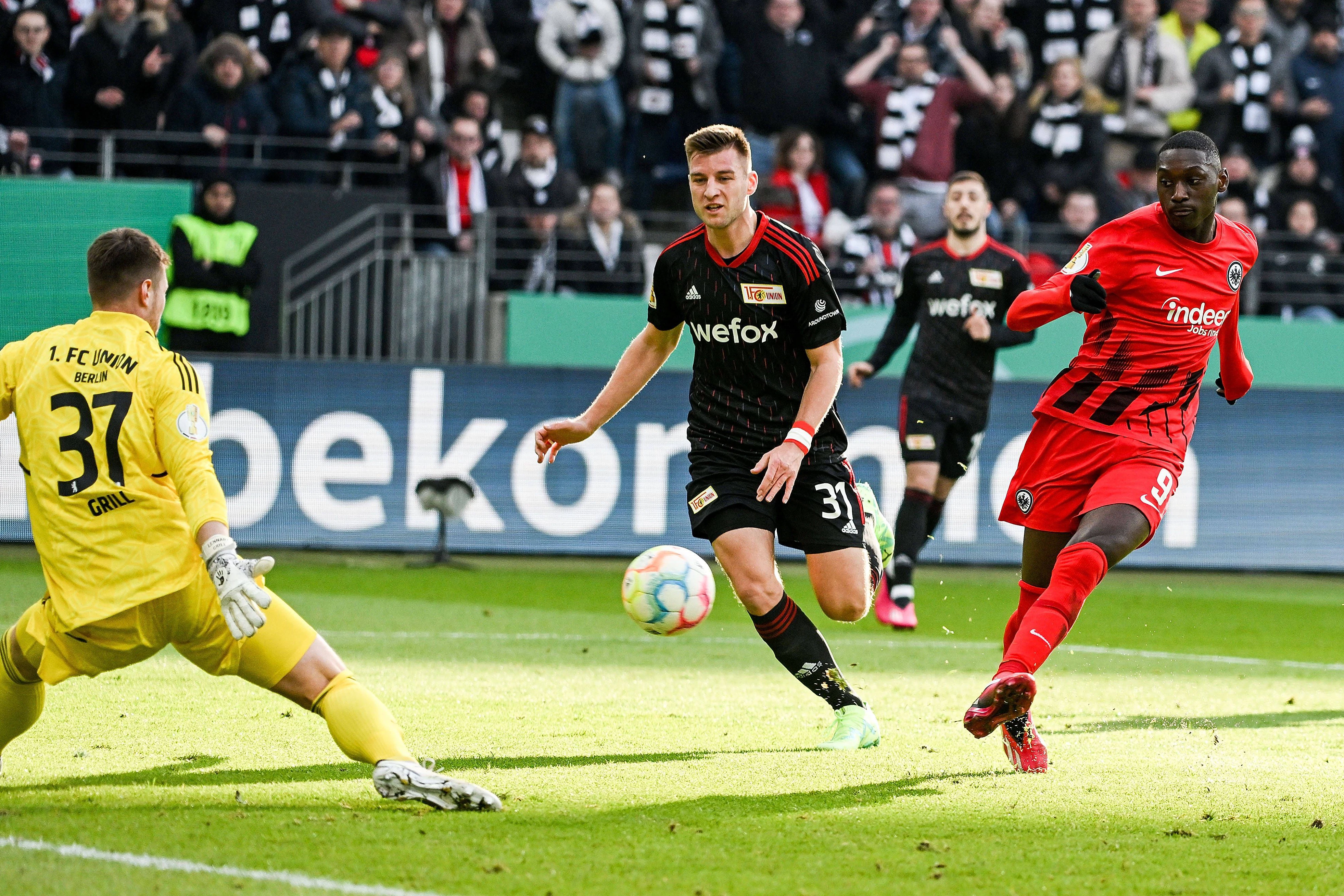 Eintracht Frankfurts Stürmer Randal Kolo Muani (r.) lässt Union Berlins Torwart Lennart Grill (l.) beim 1:0 für die Gastgeber keine Chance.