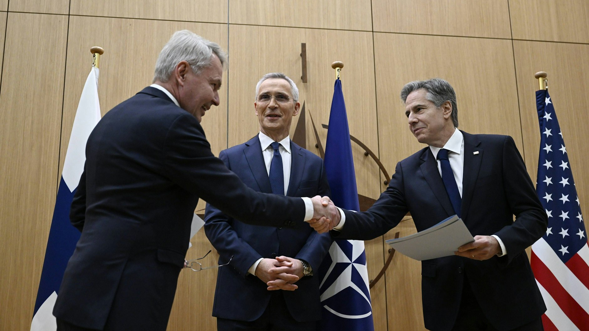 Willkommen im Club: US-Außenminister Antony Blinken (r.) gibt seinem finnischen Kollegen Pekka Haavisto im Brüsseler Nato-Hauptquartier die Hand, in der Mitte der lächelnde Nato-Generalsekretär Jens Stoltenberg. Haavisto hatte die Beitrittsurkunde an Blinken überreicht, sie wird in Washington aufbewahrt werden, dem Gründungsort der Nato.