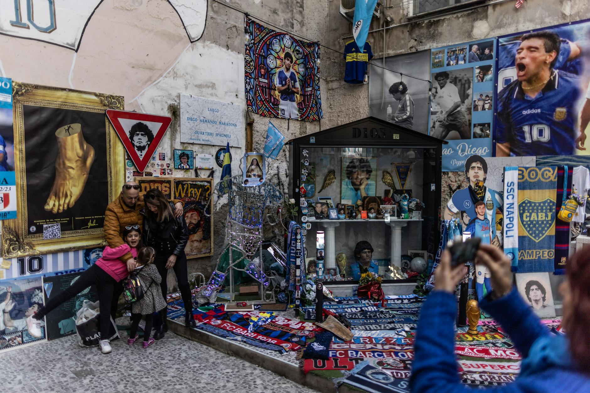Touristen machen an einem Schrein für den den ehemaligen argentinischen Fußballspieler Diego Maradona in der Via Emanuele de Deo Fotos.