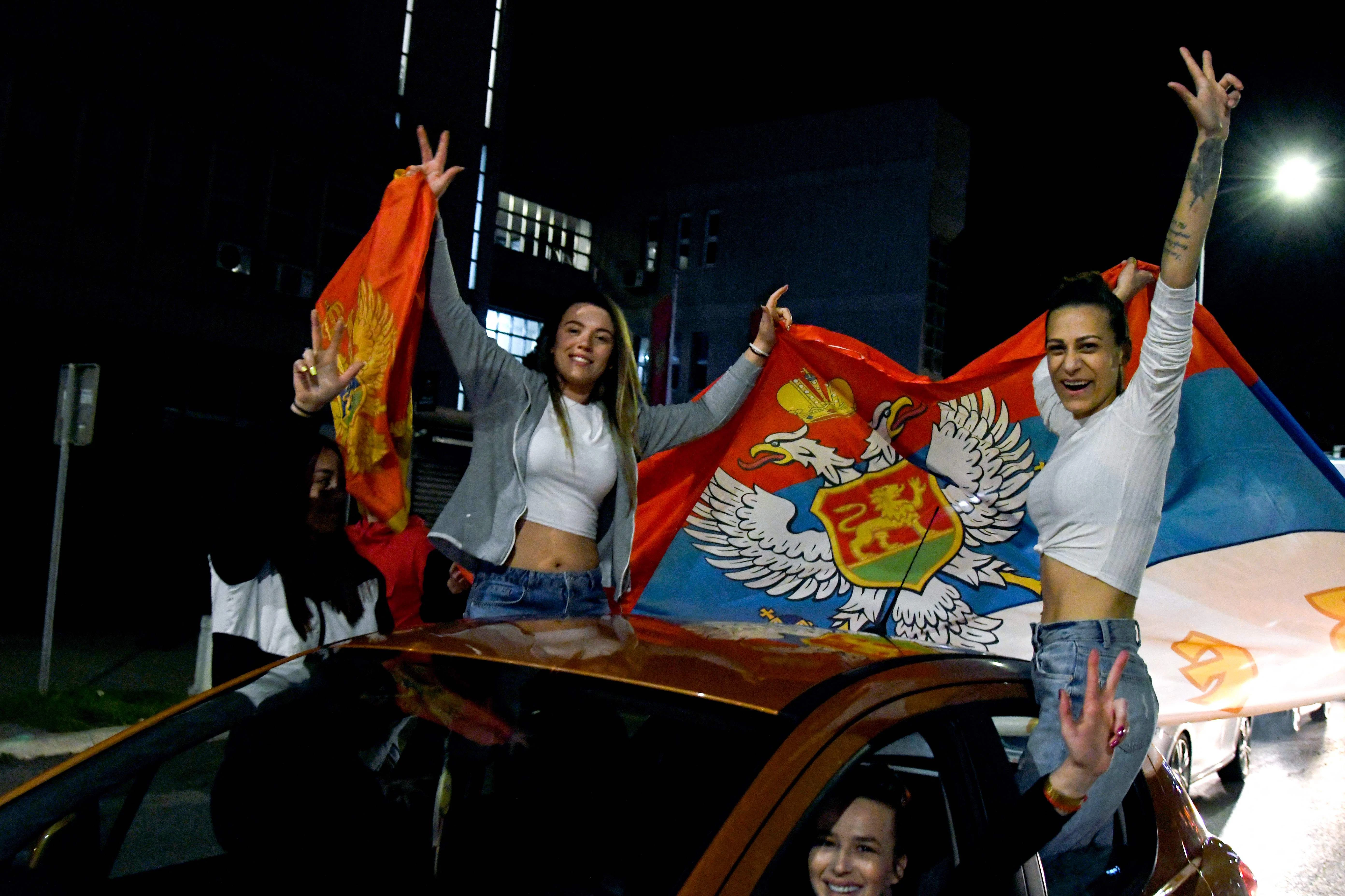 Unterstützer des neuen Präsidenten Milatović halten die montenegrinischen Flaggen.