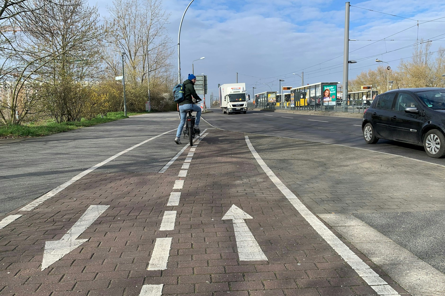 Carsten Borholter kann angesichts des Pfeils, der Radfahrer in den Gegenverkehr auf der Falkenberger Brücke schickt, nur Verwunderung äußern. Wenn er neben der Haltestellen-Bucht auf den Gehweg ausweicht, kommt er Fußgängern ins Gehege.