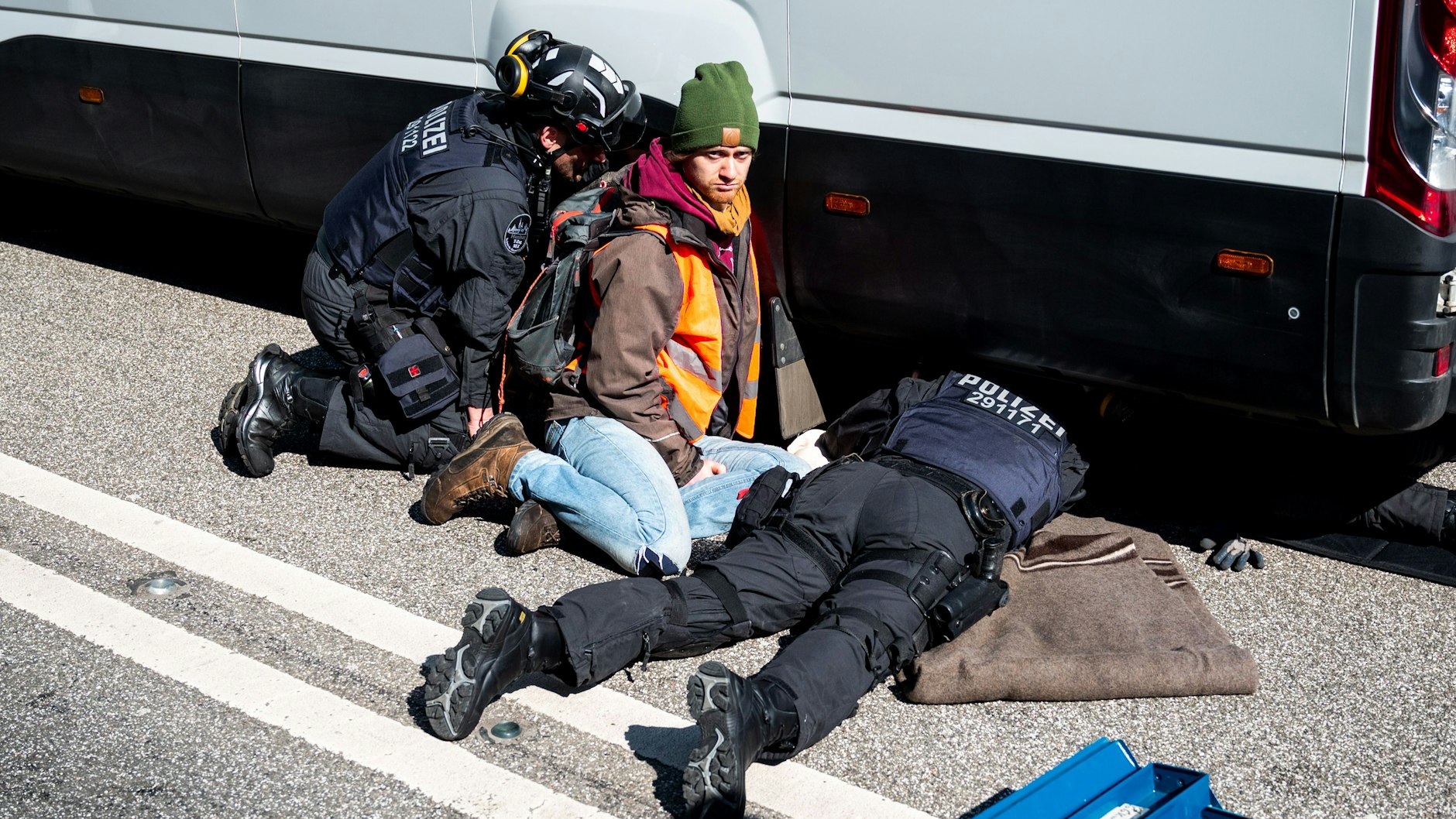 Hier klebt ein Klimakleber an einem Transporter.