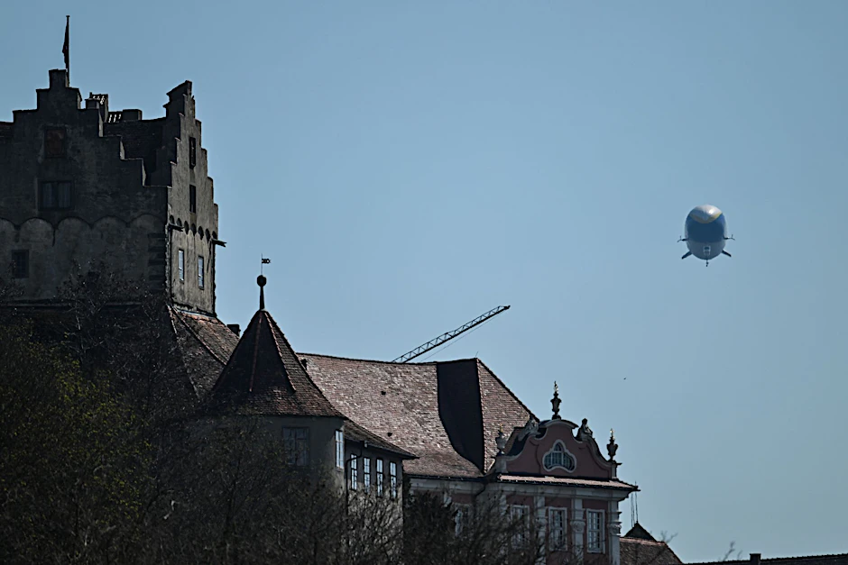 Der Zeppelin NT (Neue Technologie) fliegt an der Burg Meersburg am Bodensee entlang.  
