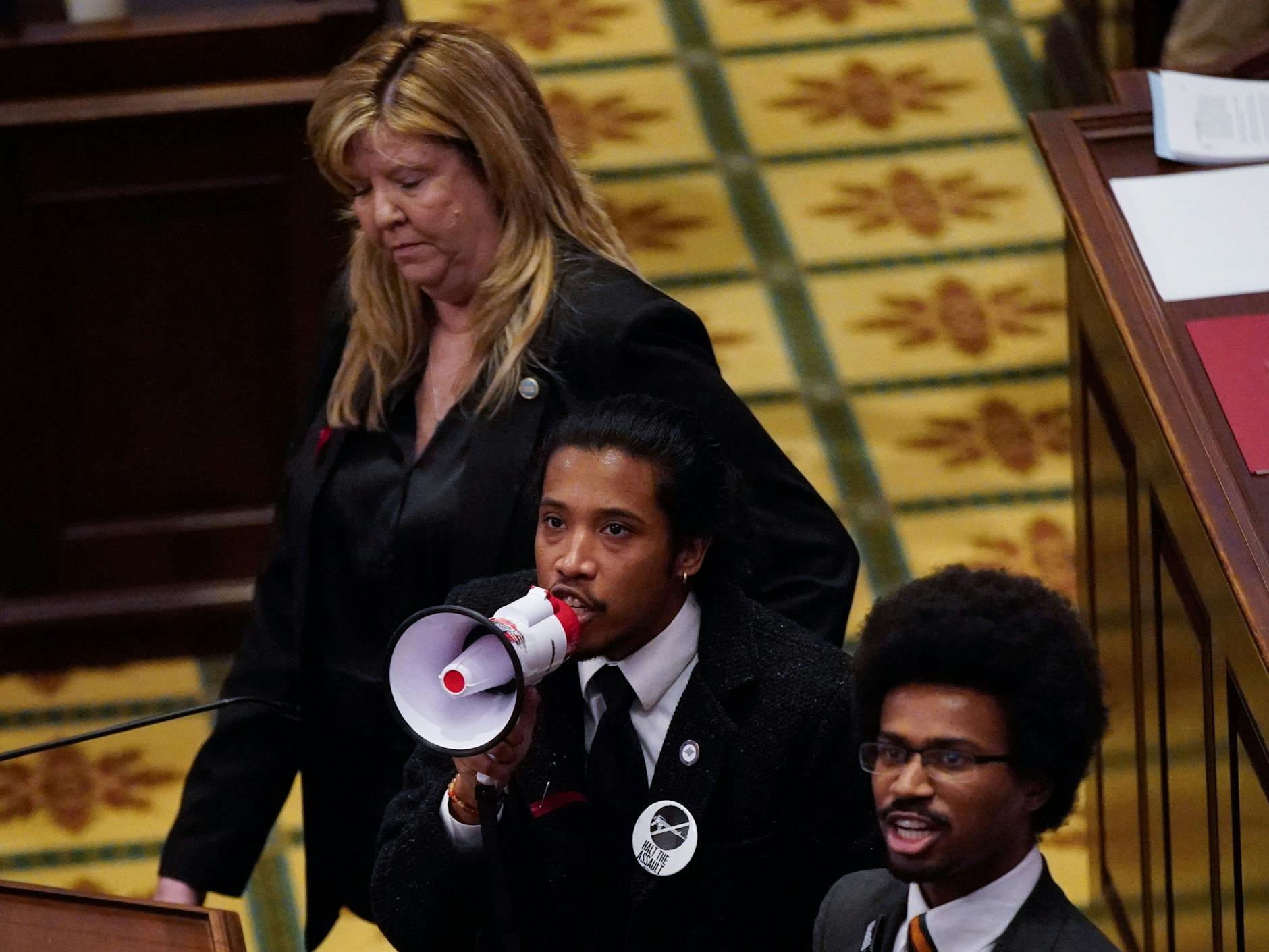 Gloria Johnson, Justin Jones und Justin Pearson wenden sich mit einem Megafon an die Demonstranten in und vor dem Parlament.
