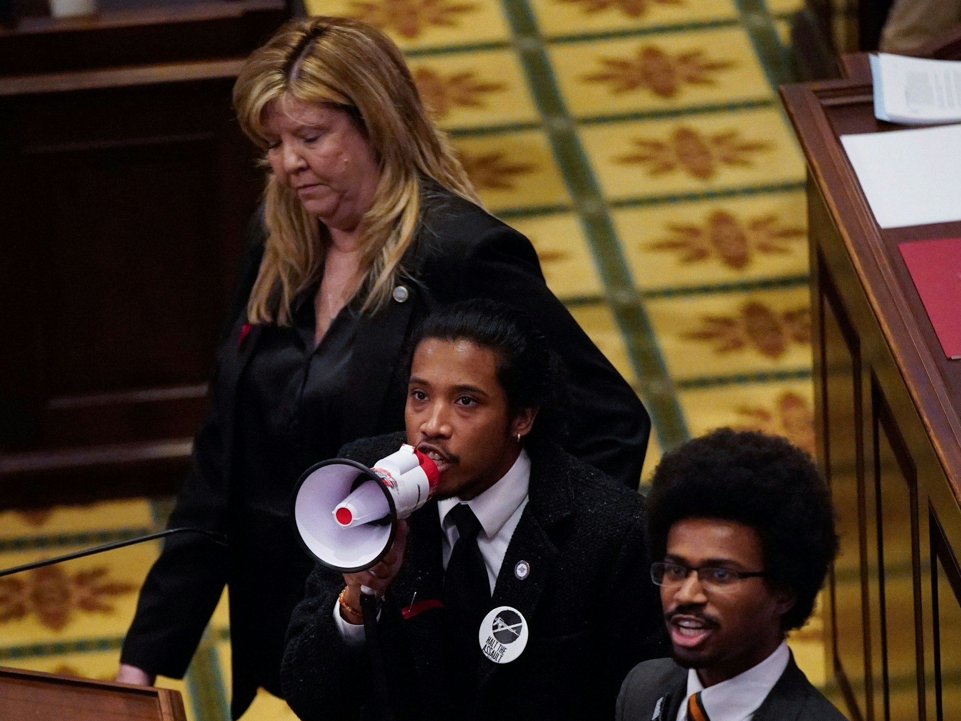 Gloria Johnson, Justin Jones und Justin Pearson wenden sich mit einem Megafon an die Demonstranten in und vor dem Parlament. 