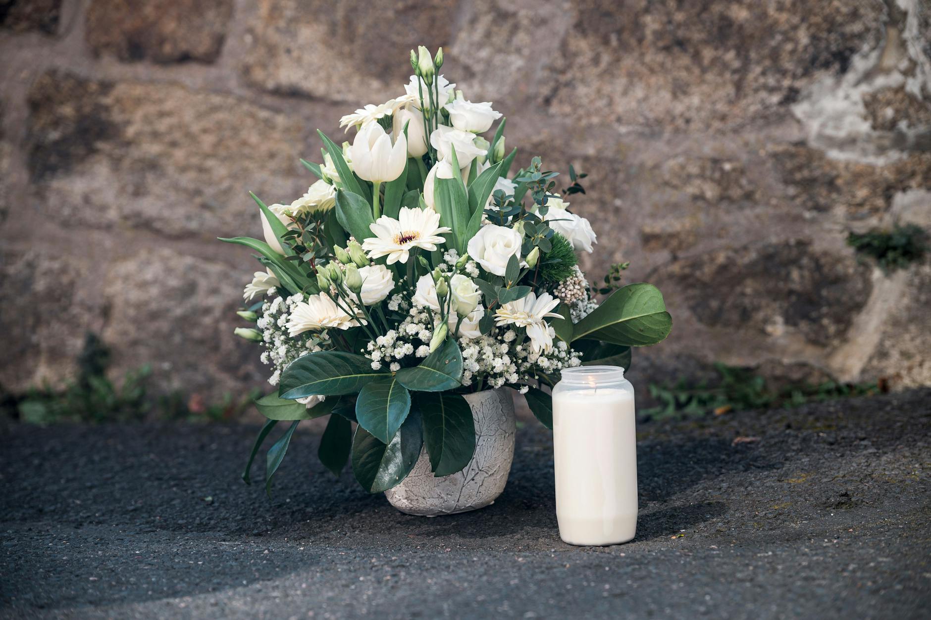 Wunsiedel: Ein Strauß Blumen und eine Kerze wurden an einer Mauer vor dem Kinder- und Jugendhilfezentrum niedergelegt. Ein zehnjähriges Mädchen war in dem Kinder- und Jugendhilfezentrum aufgefunden worden. 