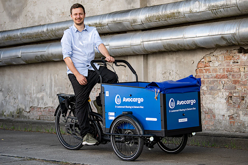 Matti Schurr, CEO und Co-Founder von Avocargo, sitzt auf einem Lastenfahrrad seiner Firma.