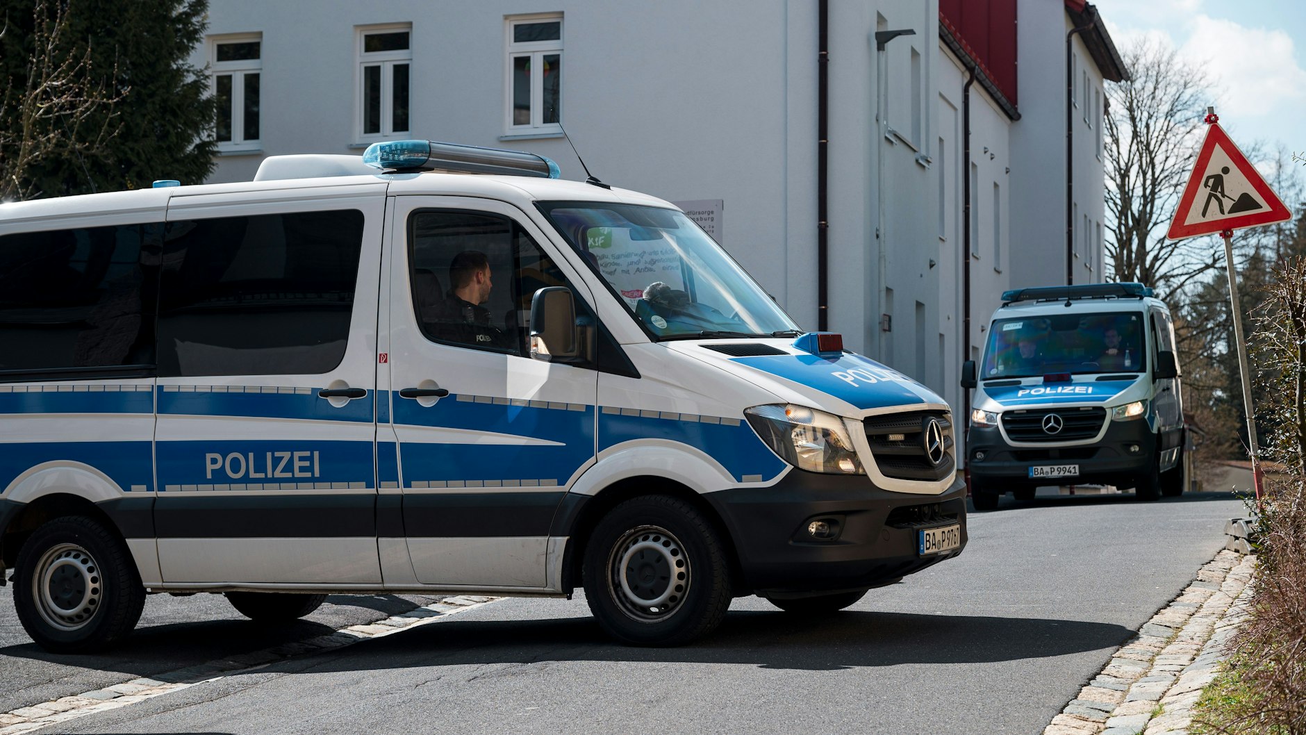 Ein Einsatzwagen der Polizei sperrt die Straße zum Kinder- und Jugendhilfezentrum ab.