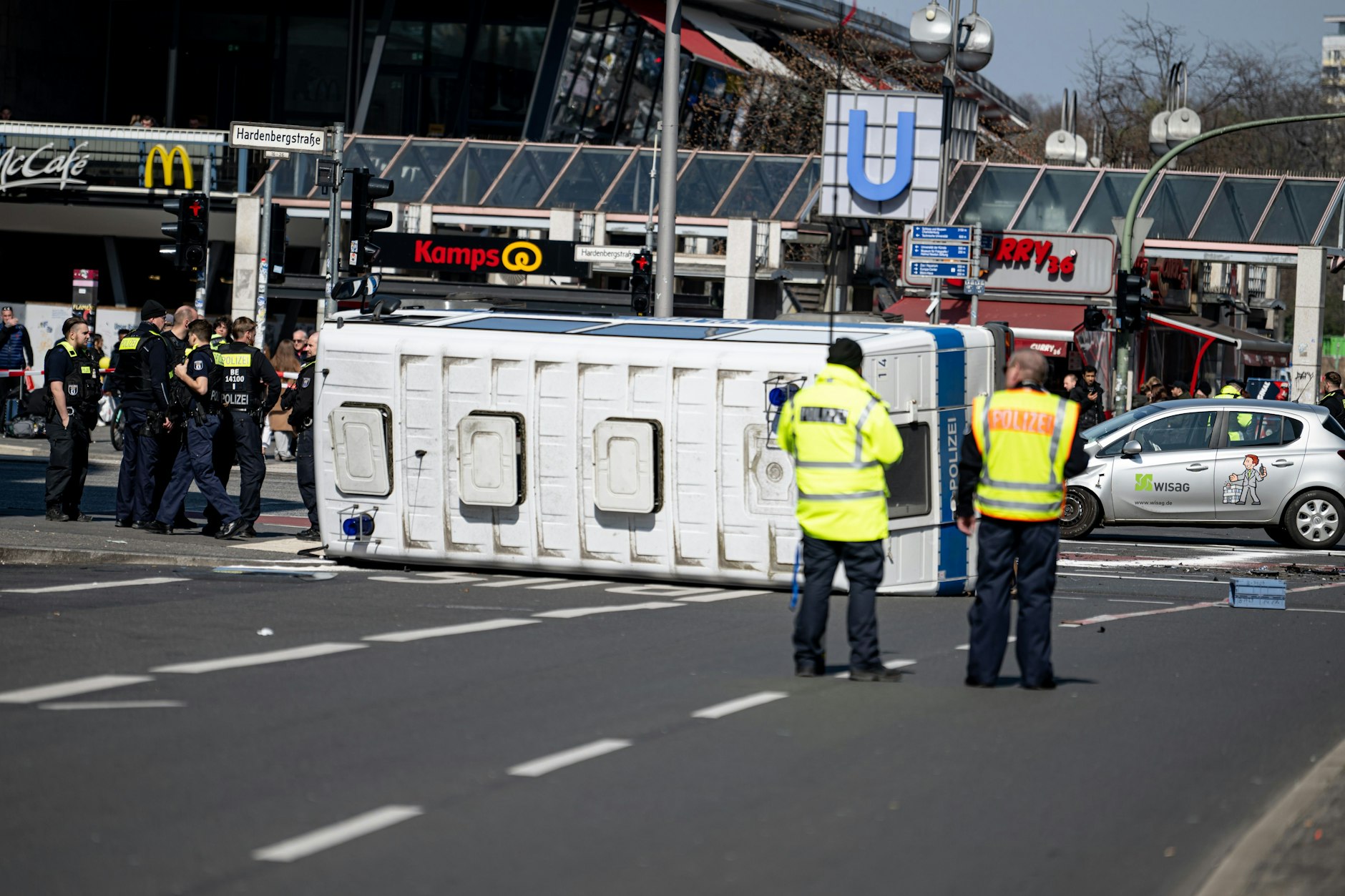 Das umgekippte Polizeifahrzeug liegt nach dem Unfall am Hardenbergplatz vor dem Bahnhof Zoo auf einer Kreuzung.