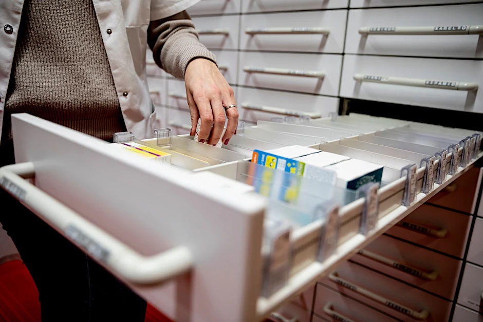 Eine Apothekerin greift in einer Apotheke in eine Medikamentenschublade.&nbsp;