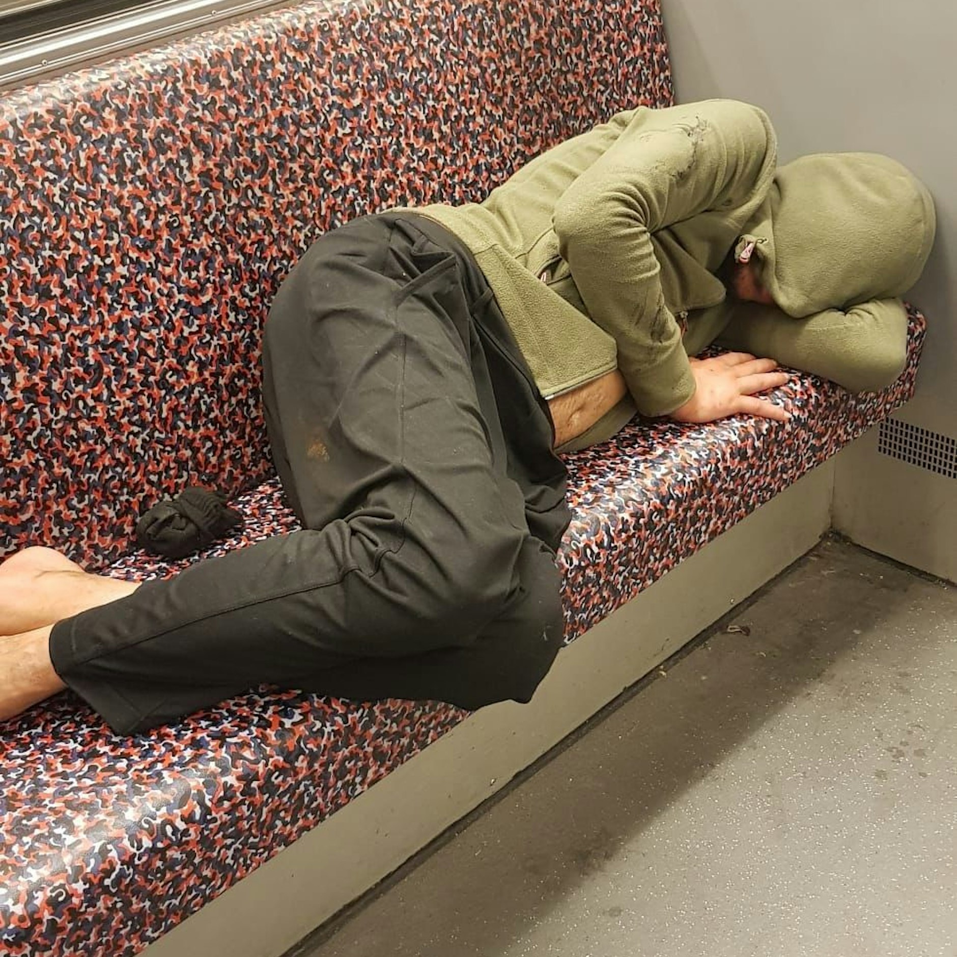 Ein Fahrgast hat sich in einer Berliner U-Bahn zum Schlafen hingelegt.
