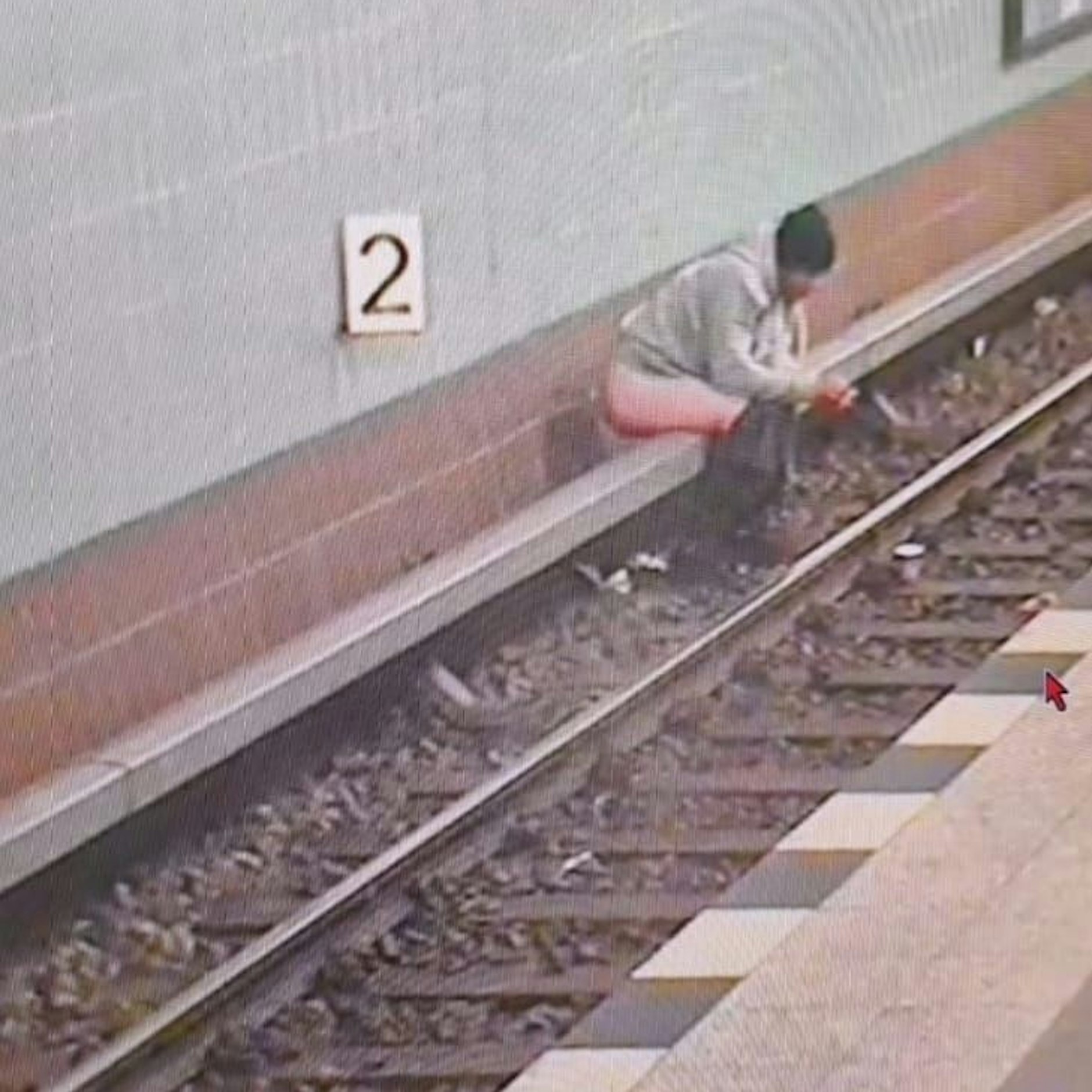 Gesehen in Berlin: Ein Mann hat sich auf einer Stromschienenabdeckung niedergelassen und nutzt den U-Bahnhof als Toilette.