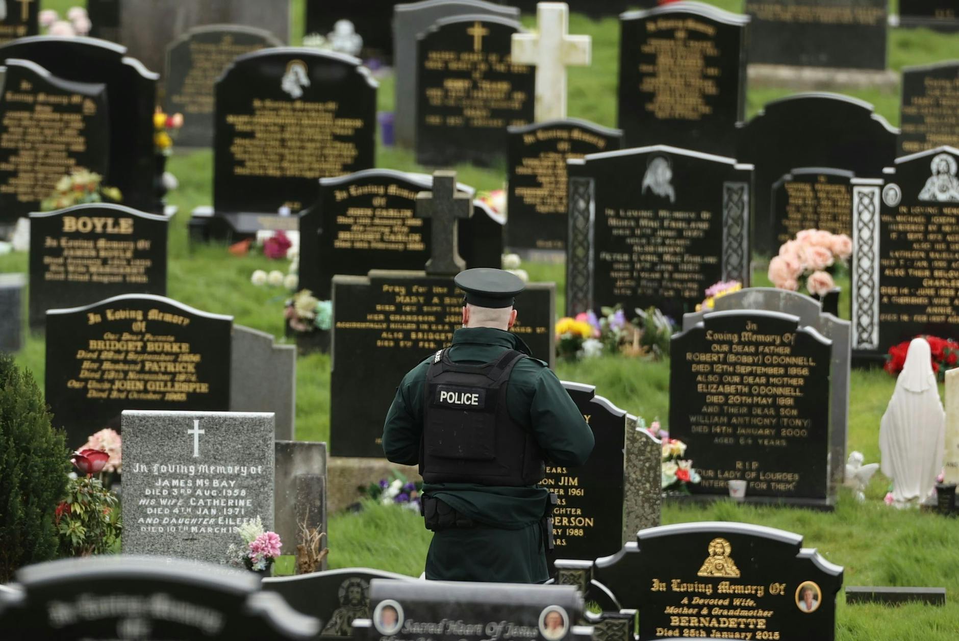 Ein PSNI-Polizist patrouilliert auf dem Stadtfriedhof von Londonderry. Kurz vor der Ankunft von US-Präsident Biden in Nordirland fand die Polizei dort vier mutmaßliche Rohrbomben.