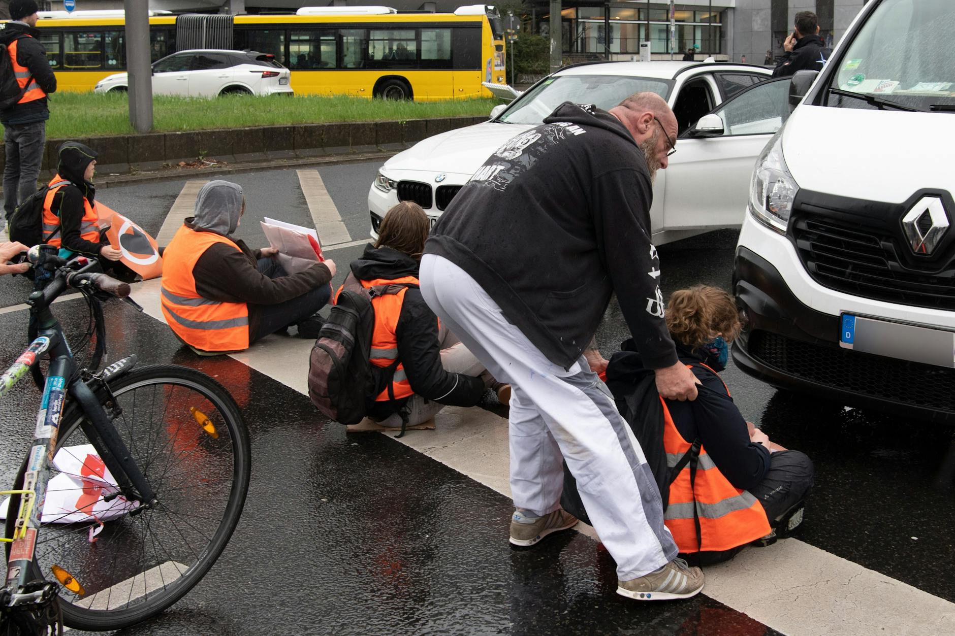 Ein Autofahrer versucht, ein Mitglieder der Gruppe Letzte Generation von einer Berliner Straße zu zerren.