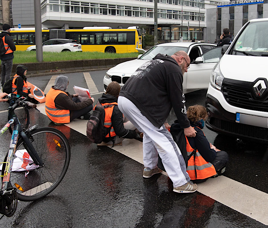 Ein Autofahrer versucht, ein Mitglieder der Gruppe Letzte Generation von einer Berliner Straße zu zerren.
