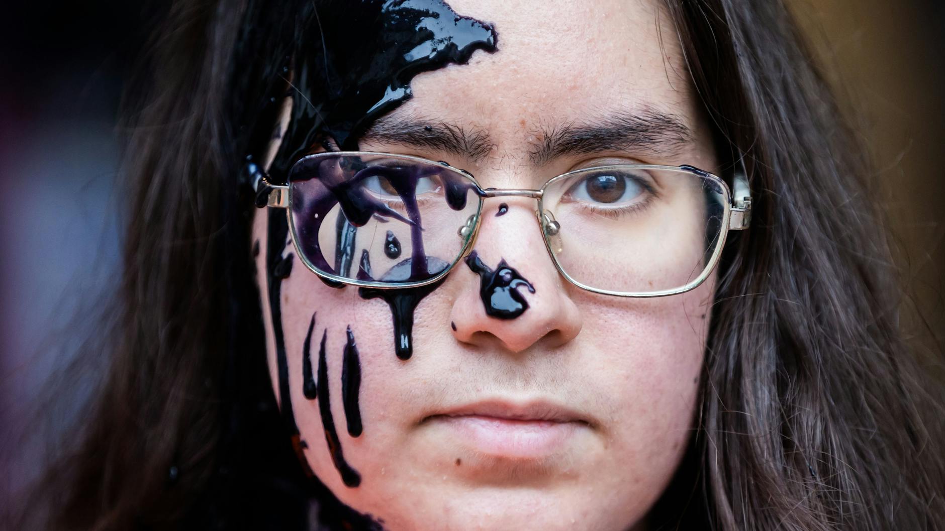 Ein Mitglied der Klimagruppe „Letze Generation“ hat vor der FDP-Zentrale Farbe im Gesicht nachdem die Parteizentrale mit dieser beschmiert wurde.