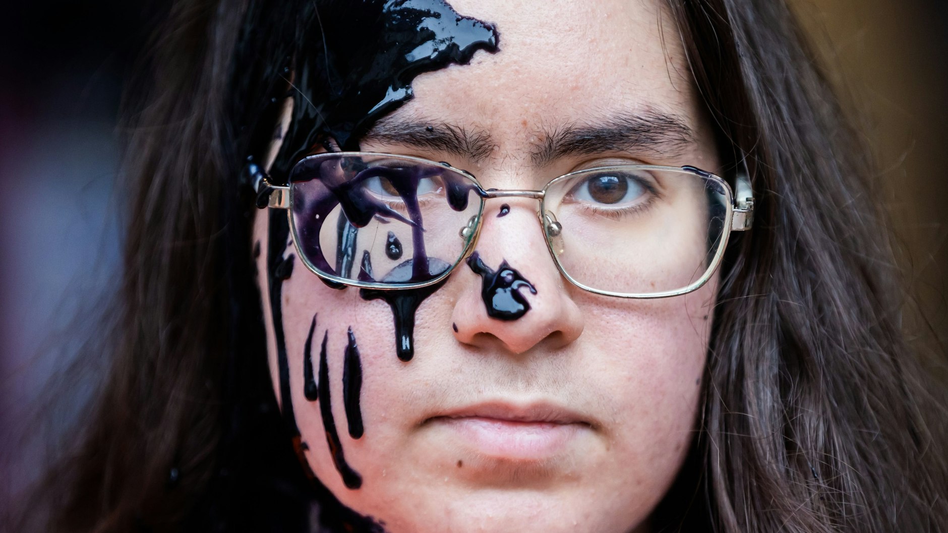 Ein Mitglied der Klimagruppe „Letze Generation“ hat vor der FDP-Zentrale Farbe im Gesicht nachdem die Parteizentrale mit dieser beschmiert wurde.