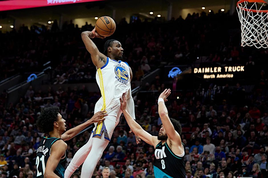 Golden State Warriors Jonathan Kuminga (M) überspringt Portland Trail Blazers John Butler Jr. (l) und Skylar Mays.  