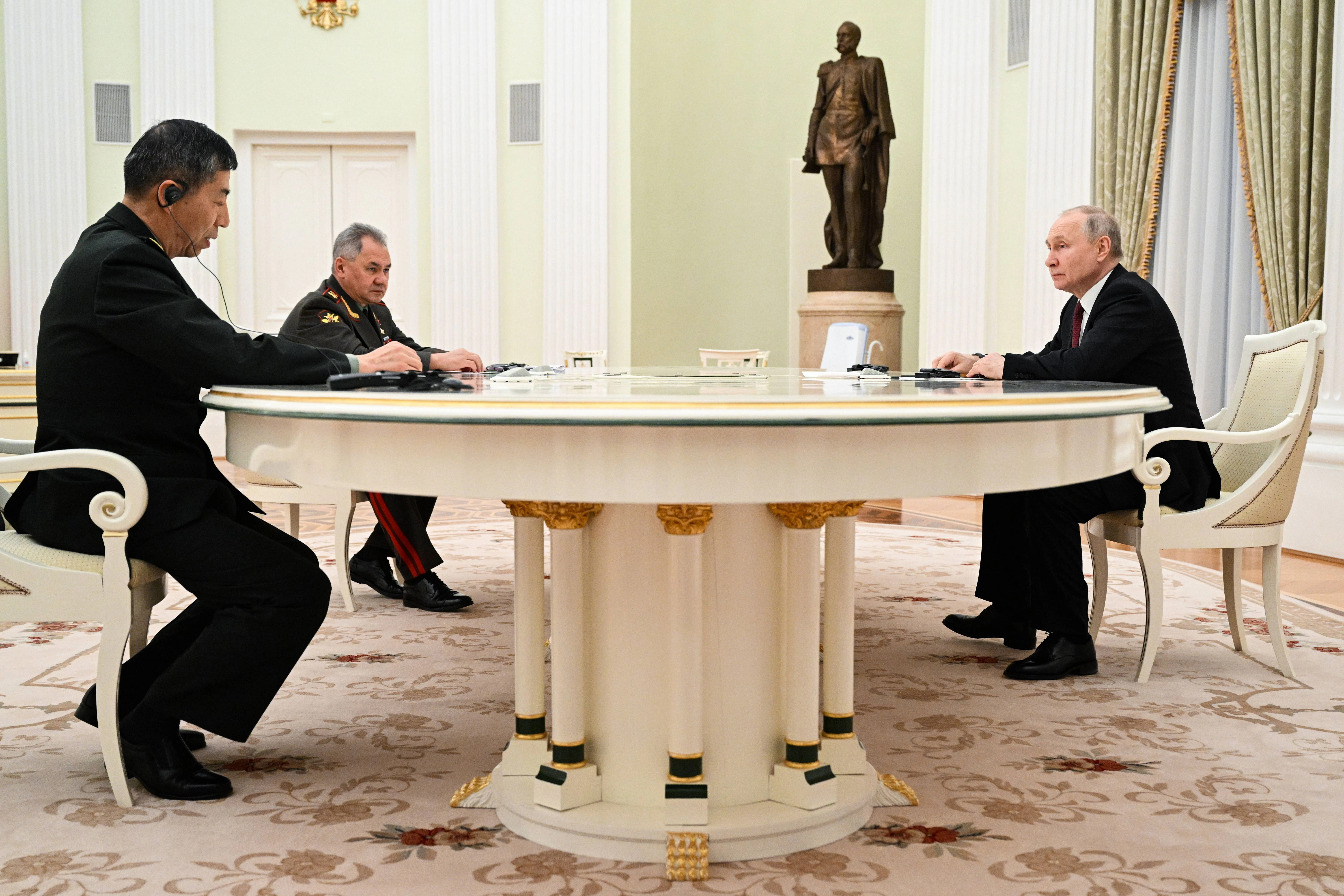 Der russische Präsident Wladimir Putin, der russische Verteidigungsminister Sergej Schoigu und der chinesische Verteidigungsminister Li Schangfu (r.l.) treffen sich im Moskauer Kreml.