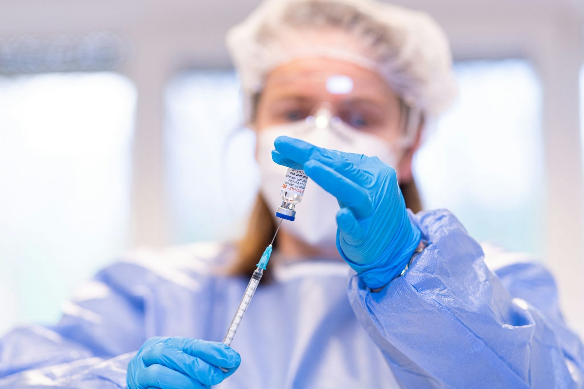Eine Spritze wird aus einem Impfstoff-Fläschchen aufgefüllt.