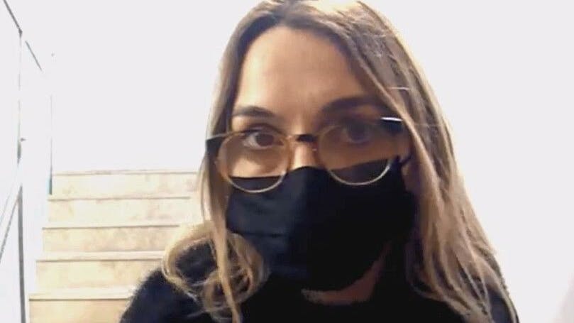 Die zweite Tatverdächtige trägt eine Corona-Maske, steht direkt vor der Tür.