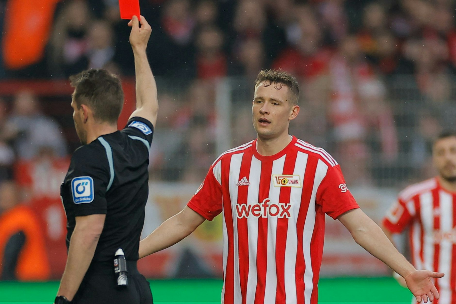 Union-Verteidiger Paul Jaeckel (r.) wird von Schiedsrichter Tobias Stieler vom Platz gestellt.