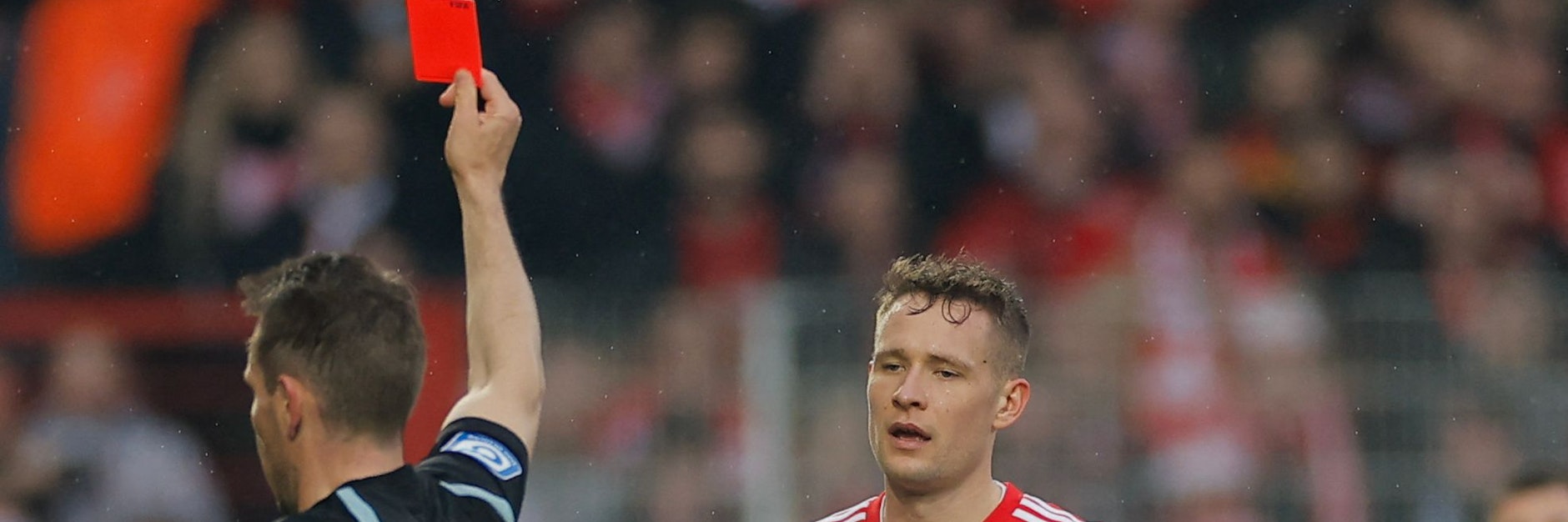 Paul Jaeckel guckt ganz geknickt, aber Schiedsrichter Tobias Stieler zeigt kein Mitleid und dem Verteidiger des 1. FC Union die Ampelkarte.