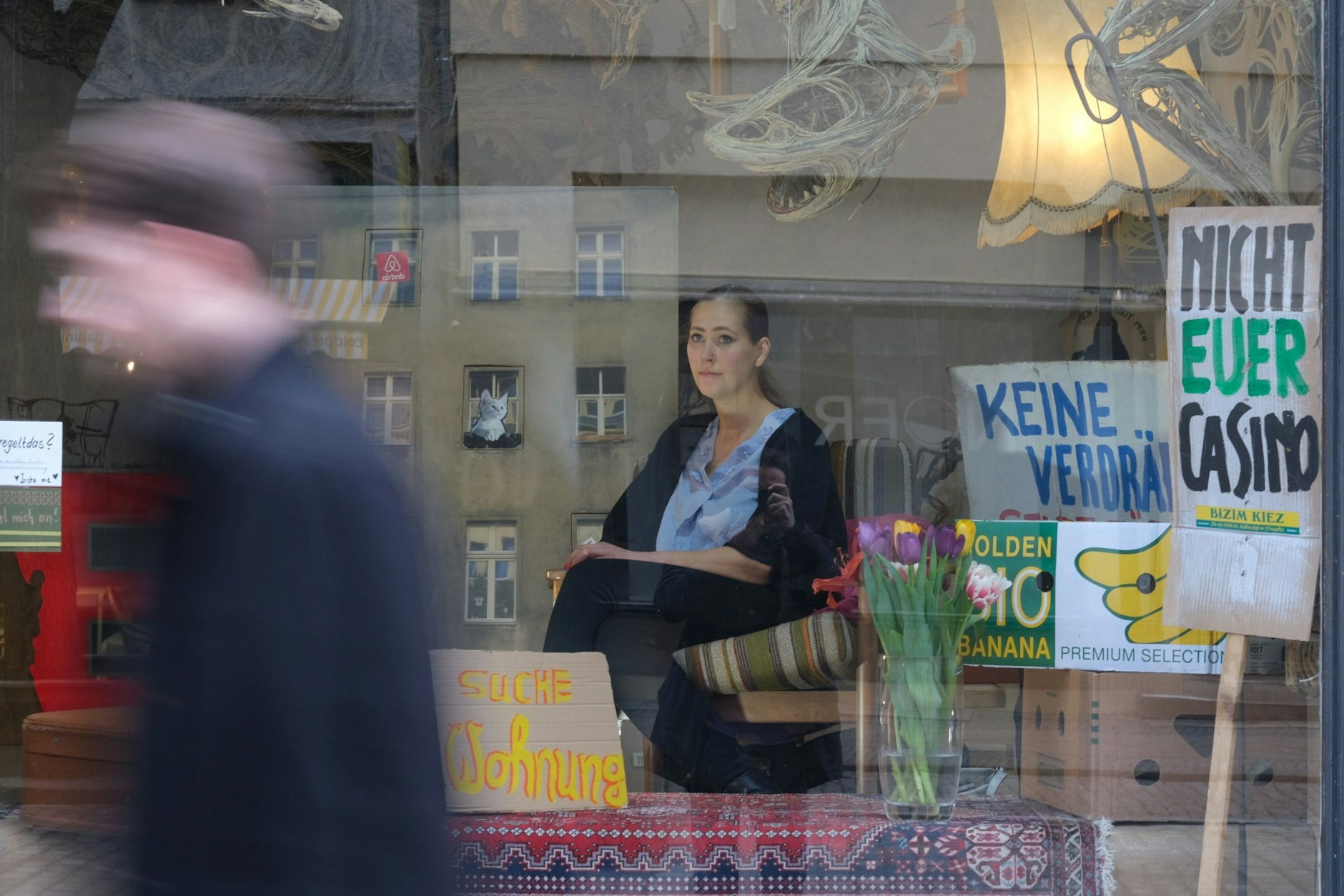 Joana V. inszeniert sich im Schaufenster als lebendige Suchanzeige.
