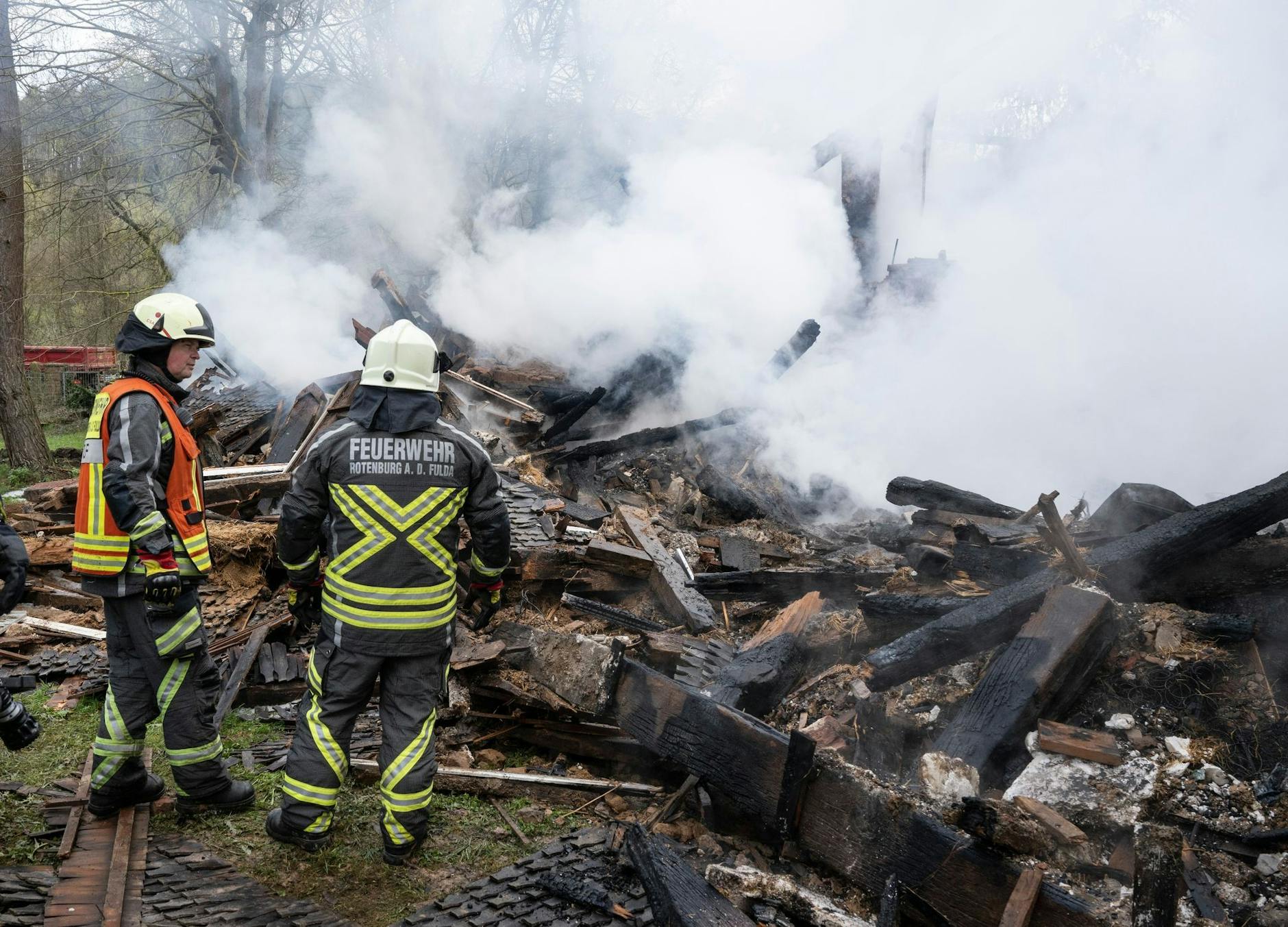 Feuerwehrleute stehen neben den noch rauchenden Trümmern des ehemaligen Hauses des «Kannibalen von Rotenburg».