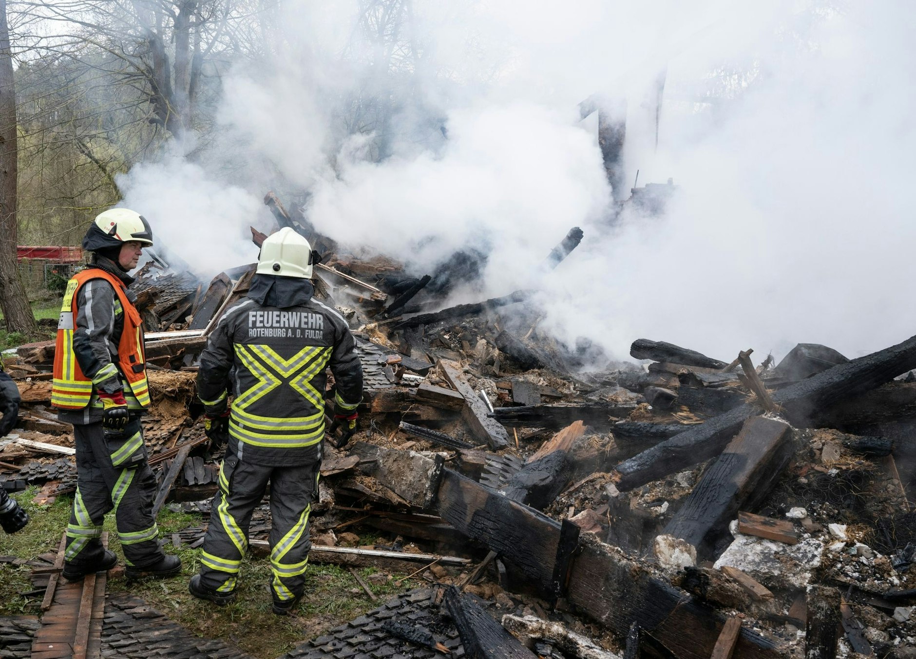 Feuerwehrleute stehen neben den noch rauchenden Trümmern des ehemaligen Hauses des «Kannibalen von Rotenburg».  