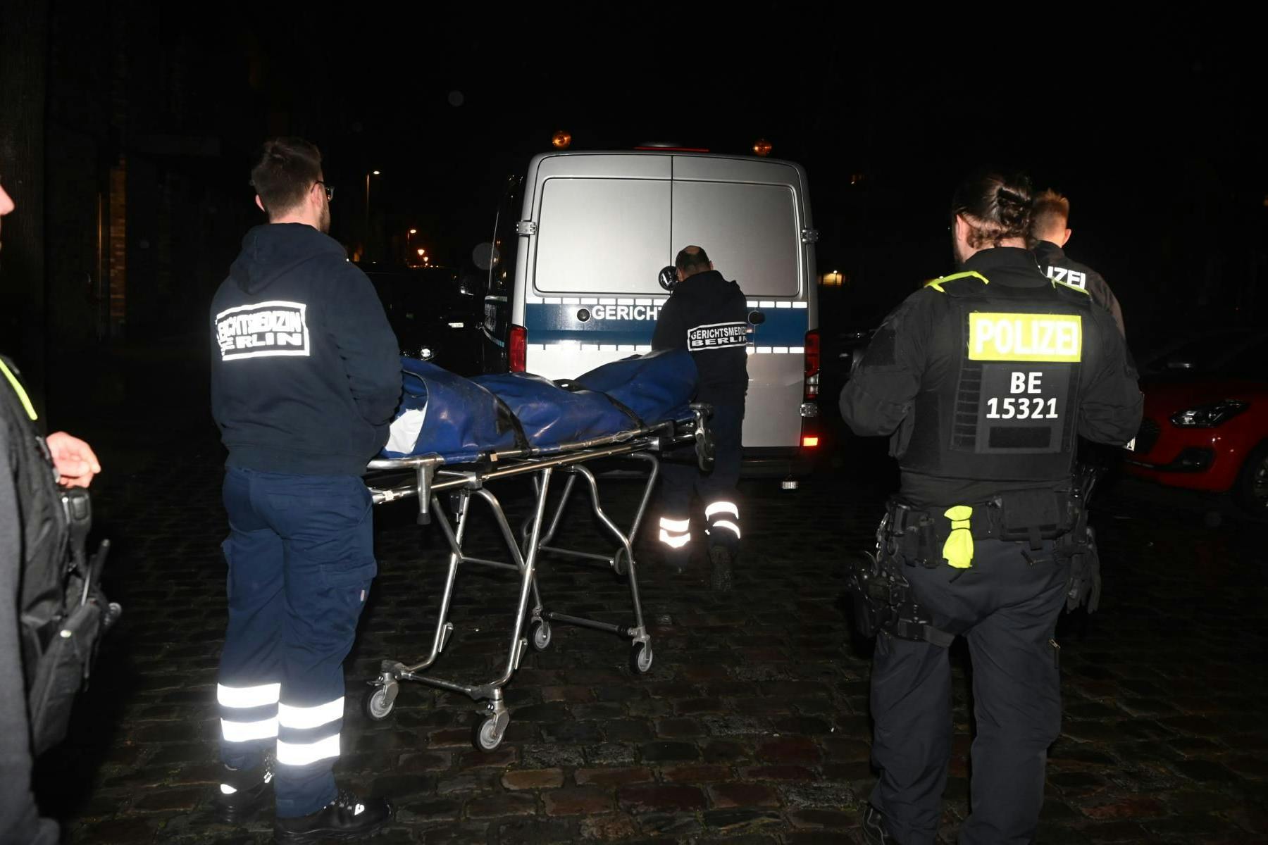 Die Weserstraße in Berlin-Friedrichshain: Mitarbeiter der Rechtsmedizin transportieren die Leiche ab.