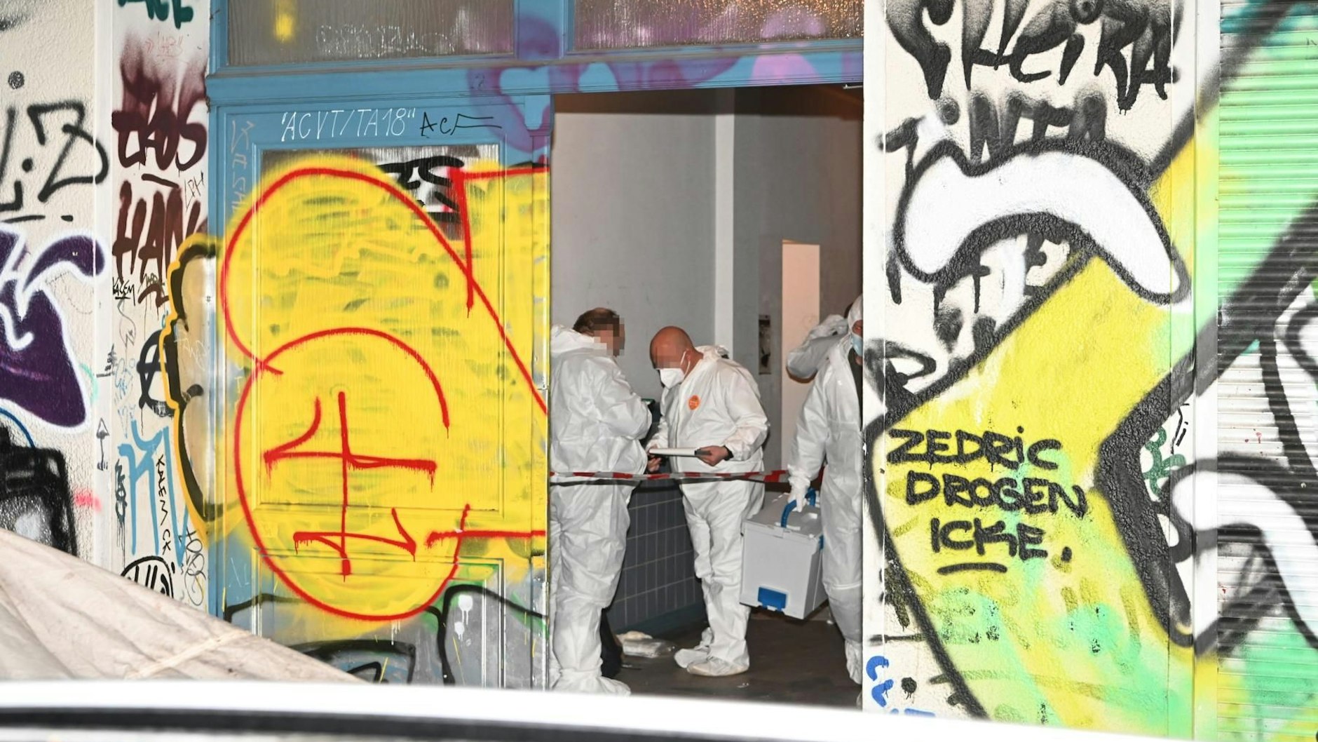 Kriminaltechniker sichern im Eingangsbereich des Mietshauses Spuren.