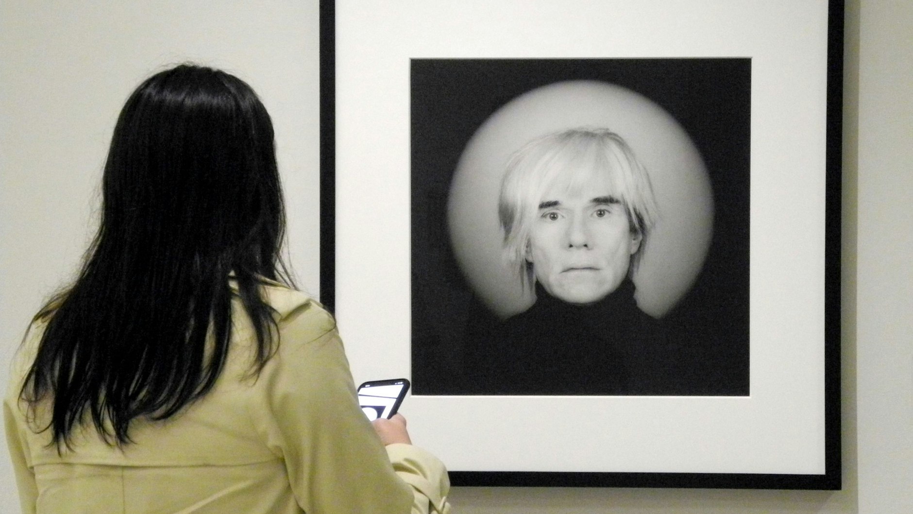 Eine Frau betrachtet bei einer Ausstellung ein Foto von Andy Warhol, das Robert Mapplethorpe (1946-1989) gemacht hatte.