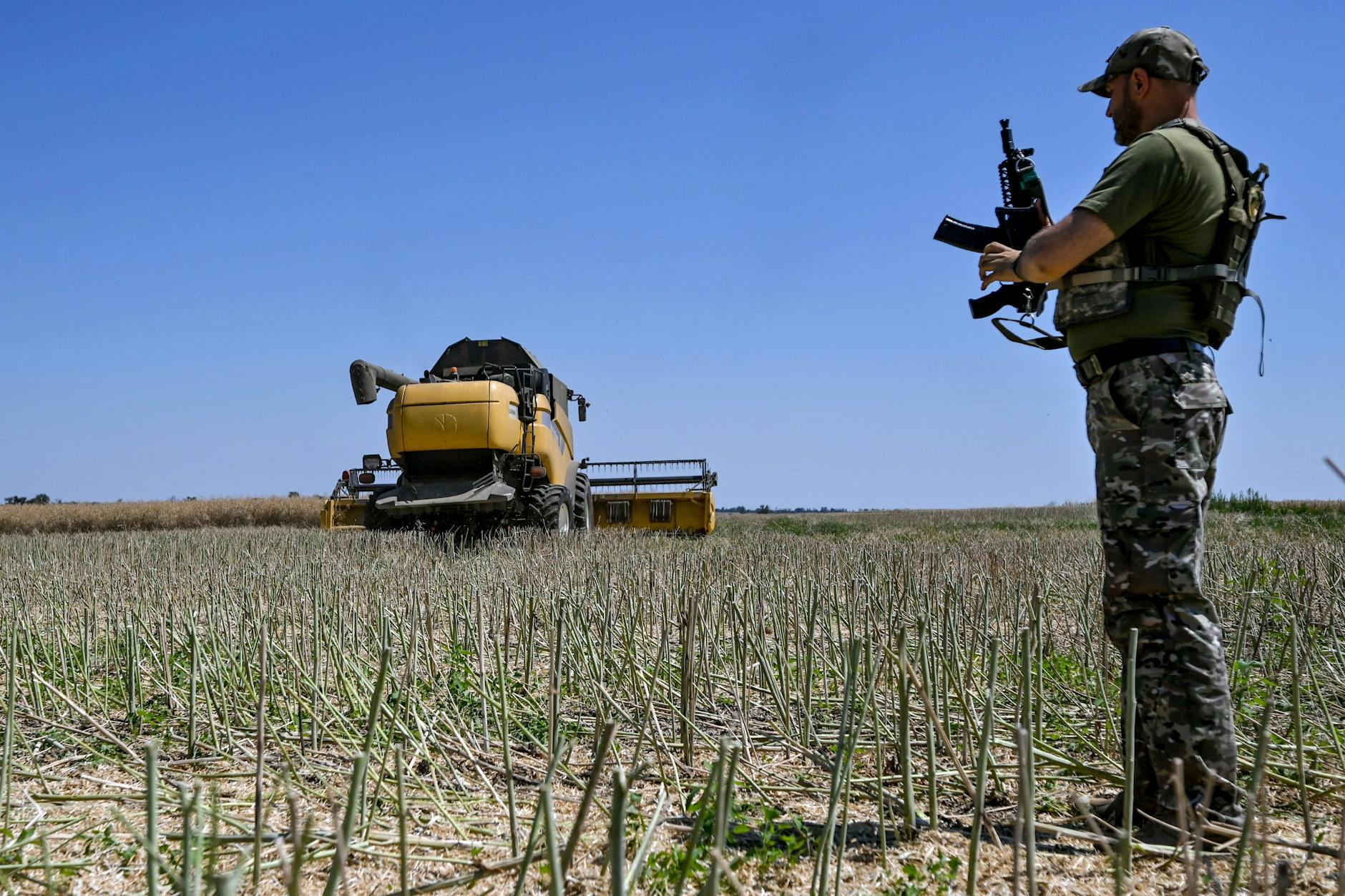 Ein Soldat sichert während der Ernte einen Mähdrescher in der ukrainischen Region Saporischschja.