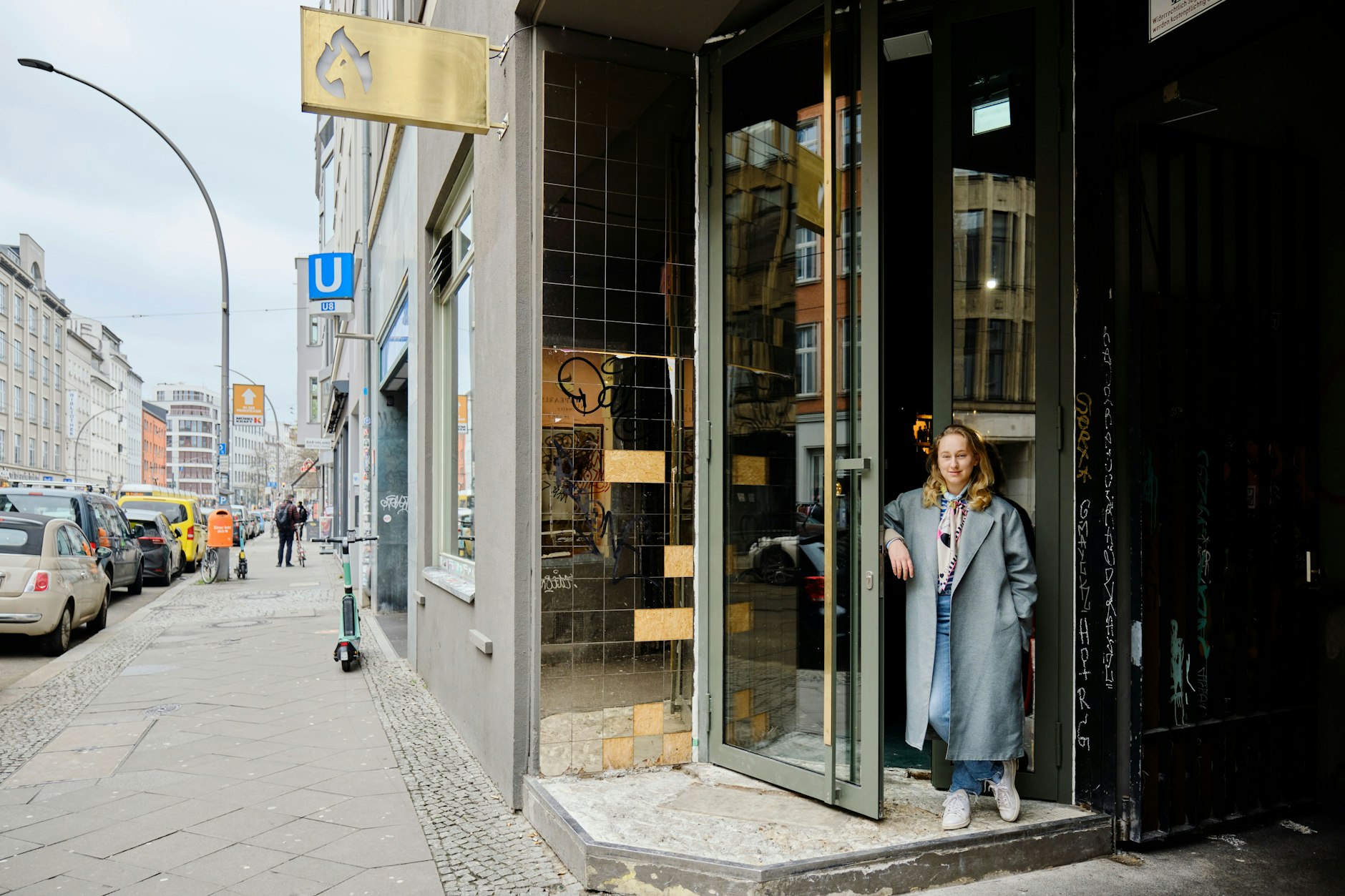 Anna Müller an der Troya-Tür in der Brunnenstraße. Direkt neben der Bar führt eine Treppe zur U8 in den Berliner Untergrund. Das Haus gehört Jean-Remy von Matt, der eine Wohnung im Dachgeschoss hat.